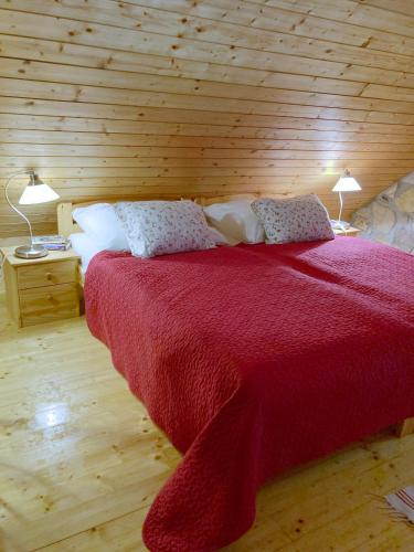a bedroom with a large red bed with two lamps at Zsóka Fogadója in Szentantalfa