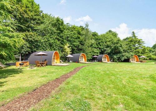 a group of tents in a field with trees at Apple Mount Retreat in Lavenham