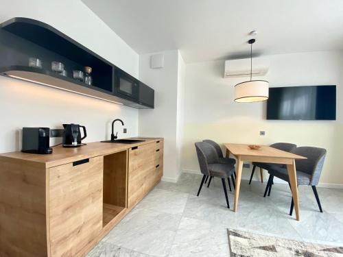 a kitchen and dining room with a table and chairs at H11 Aparthotel in Kraków