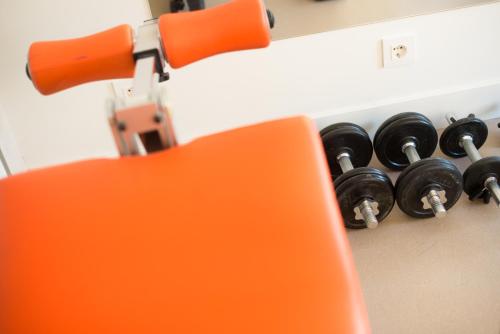 an orange chair sitting next to a bunch of black objects at Hotel Boreal Viento Norte in Burgos