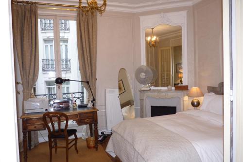 une chambre avec un lit, un bureau et un miroir dans l'établissement Prestigious 2 bedroom near Champs Elysées, à Paris