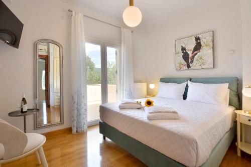 - une chambre avec un lit et une grande fenêtre dans l'établissement Bella Dassia, à Dafnila