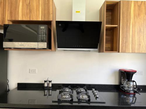 a kitchen with a microwave and a stove top oven at La casa del Rincon in Querétaro