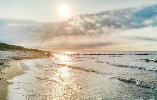 ein Strand mit einer Gruppe von Menschen im Wasser in der Unterkunft Holiday Home Mielno Akacjowa in Mielno