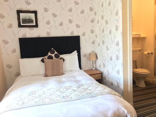 a bed with a black headboard in a bedroom at The Old Coach House in Buckie