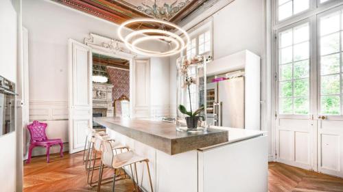 a kitchen with a large island with stools at Napoleon Chateau Luxuryapartment for 18 guests with Pool near Paris! in Saint-Jean-aux-Bois