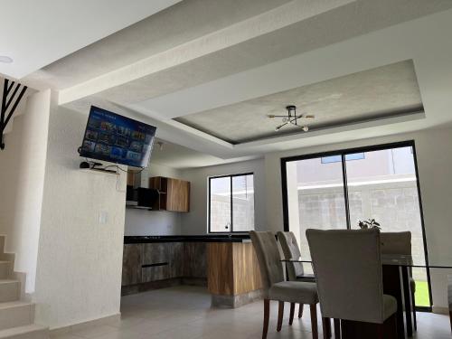 a dining room with a table with chairs and a tv at La casa del Rincon in Querétaro