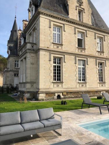 - un canapé installé devant un grand bâtiment dans l'établissement Napoleon Chateau Luxuryapartment for 18 guests with Pool near Paris!, à Saint-Jean-aux-Bois