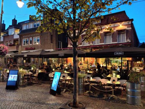 un grupo de mesas y sillas frente a un restaurante en BijHillen in bed en Winterswijk