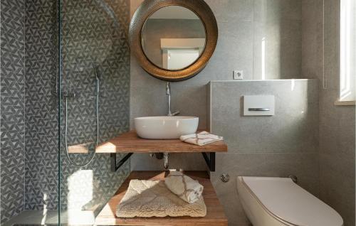ein Badezimmer mit einem Waschbecken, einem Spiegel und einem WC in der Unterkunft Beach Front Home In Lukovo Sugarje With Jacuzzi in Lukovo Šugarje