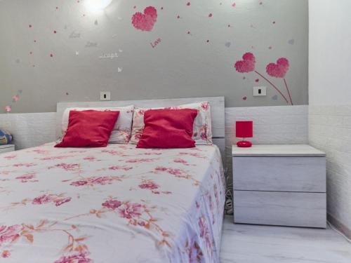 1 dormitorio con 1 cama con corazones rosados en la pared en Sweet Home Appartamento 4 posti letto 10 min dal mare en Badalucco