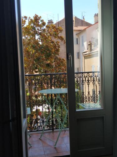 una puerta que da a un balcón con mesa en STUDIO CANNES A 5 MN A PIED DE LA GARE TOUT CONFORT AVEC BALCON, en Cannes