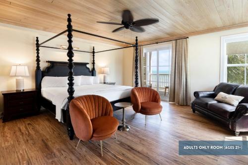 a bedroom with a bed and two chairs and a ceiling fan at Grassy Flats Resort & Beach Club in Marathon