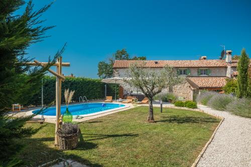 a garden with a swimming pool and a house at Villa Nonni-romantic stone house in Višnjan
