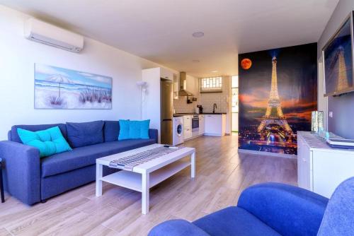 a living room with a blue couch and a table at La Cascada 202 in Puerto Rico de Gran Canaria