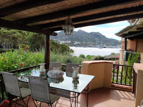 un tavolo e sedie su un balcone con vista sull'acqua di Appartamento Porto Cervo Dolce Sposa a Porto Cervo