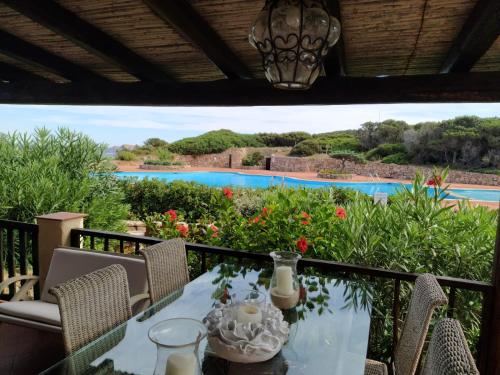 un tavolo su un balcone con vista sulla piscina di Appartamento Porto Cervo Dolce Sposa a Porto Cervo