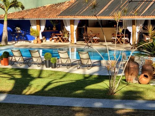 un complejo con una piscina con sillas y mesas en Saison Resort & Spa, en Itaipava