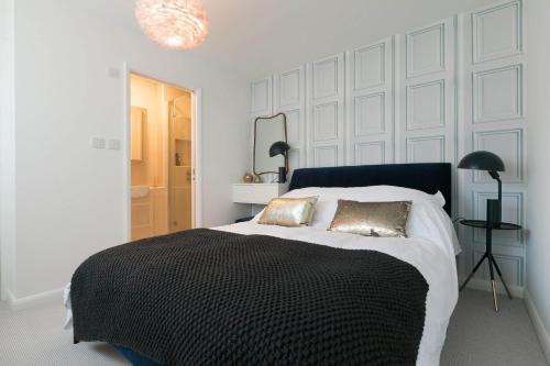 a white bedroom with a large bed with two pillows at Golden Heights in Carbis Bay