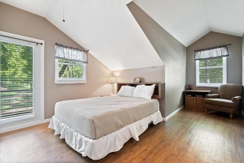 1 dormitorio con 1 cama grande y 2 ventanas en Wilstem Cabins, en French Lick