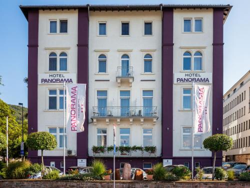 a white building with flags in front of it at Hotel Panorama in Heidelberg