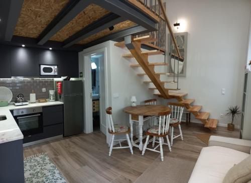 a kitchen and dining room with a wooden table and stairs at Domus Duorum in Porto