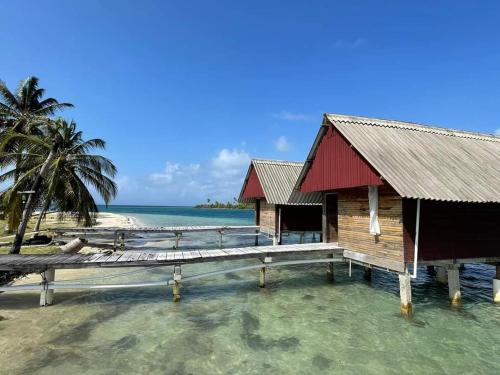 a building on the water with a dock on a beach at Cabañas Waili in Niatupo