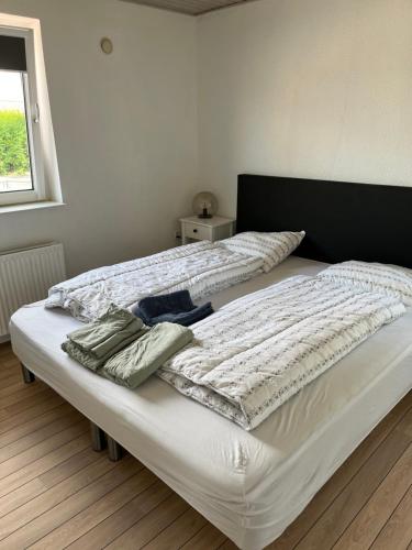 Una cama con edredón blanco y toallas. en Casa Markskellet, Billund - hygge og leg for alle en Billund