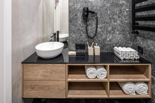 ein Badezimmer mit einem Waschbecken und einer Theke mit einem Waschbecken in der Unterkunft Apartment On Kulisha 28 in Lwiw