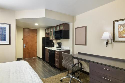 a hotel room with a bed and a desk and a kitchen at Candlewood Suites NYC -Times Square by IHG in New York