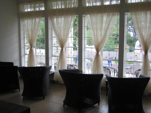 a group of chairs sitting in front of a window at Villa Osumare Guest House in Flic-en-Flac