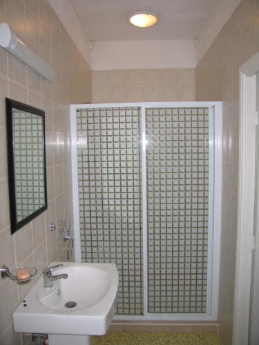 a bathroom with a sink and a shower with a window at Villa Osumare Guest House in Flic-en-Flac