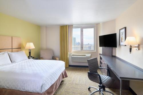a hotel room with a bed and a desk at Candlewood Suites NYC -Times Square by IHG in New York