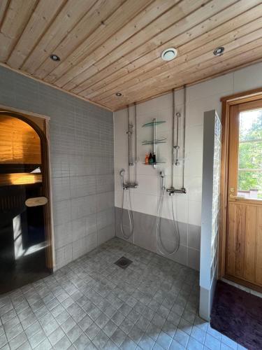 a bathroom with a shower stall and a wooden ceiling at Levin Ruska B in Kittilä