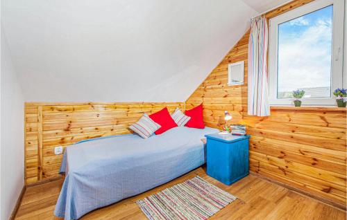 a bedroom with a blue bed with red pillows at Amazing Home In Ustka-przewloka With 3 Bedrooms And Wifi in Ustka