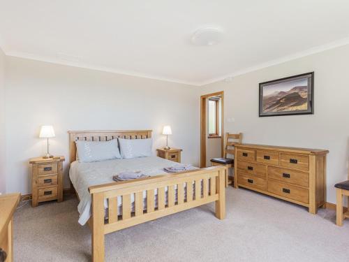 a bedroom with a wooden bed and two night stands at Askival in Elgol