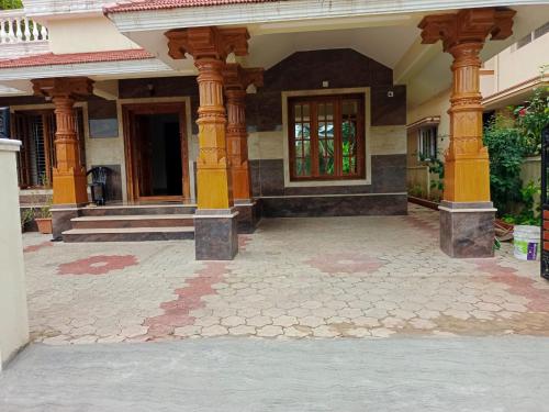 um edifício com colunas e uma porta num pátio em Sri Krishna Palace em Mangalore