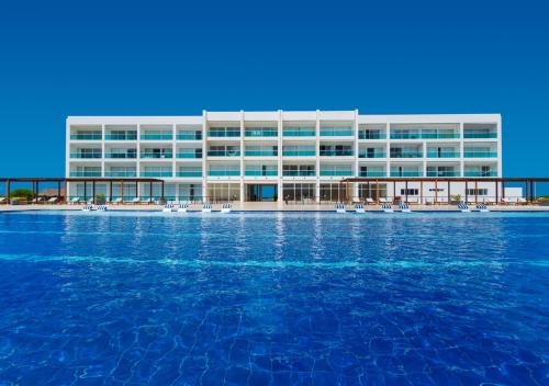 a large building with blue water in front of it at Marina Puerto Velero in Tubará