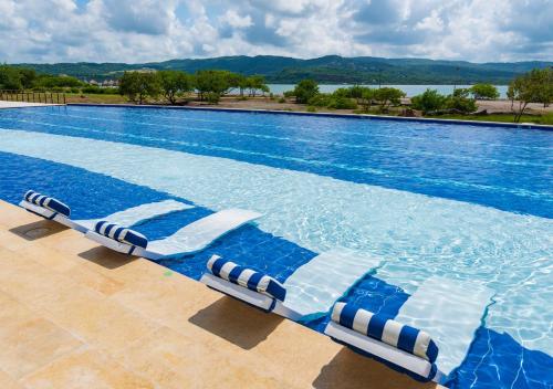 a large swimming pool with two lounge chairs in it at Marina Puerto Velero in Tubará