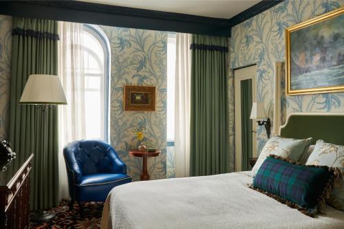 1 dormitorio con 1 cama y 1 silla azul en Marine Troon en Troon
