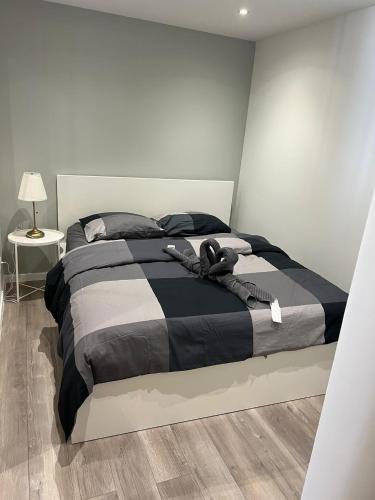 une chambre avec un lit avec une couette noire et blanche dans l'établissement App 1 Mulhouse centre , 6 personnes, à Mulhouse