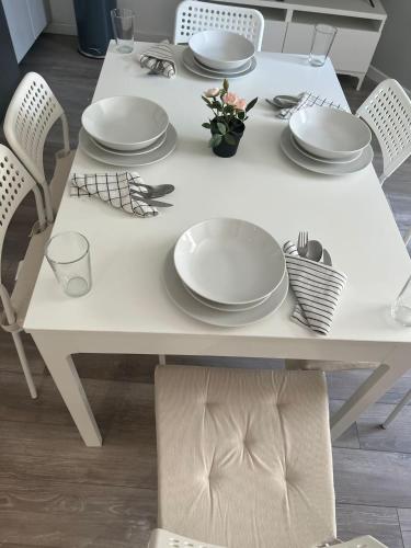 - une table blanche avec des assiettes et des ustensiles dans l'établissement App 1 Mulhouse centre , 6 personnes, à Mulhouse