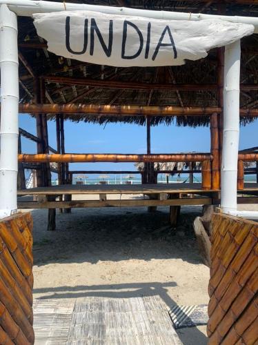 a bench on the beach with a sign on it at Un Dia Boutique Resort in Playas