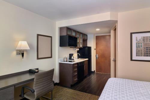 a hotel room with a bed and a desk and a kitchen at Candlewood Suites NYC -Times Square, an IHG Hotel in New York