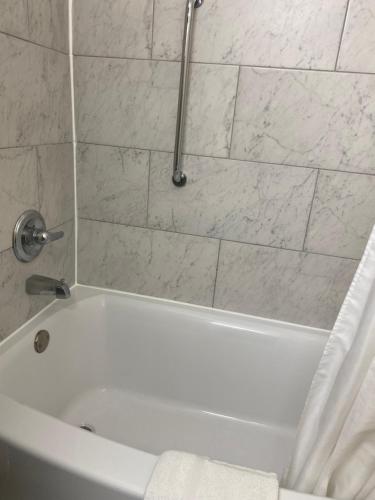a bathroom with a white tub with a shower curtain at Savannah Motel in Savannah