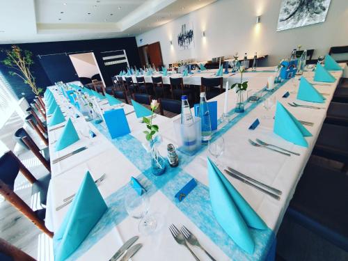 a long long table with blue napkins on it at Hotel Krone in Königsbrunn