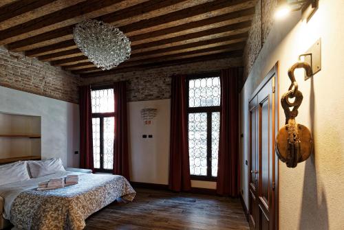 1 dormitorio con 1 cama en una habitación con ventanas en Gradenigo Apartments 767, en Venecia