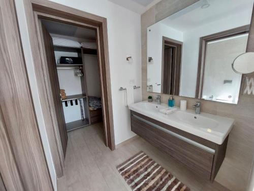 a bathroom with a sink and a mirror at Spectacular Apto Pool Golf View in Hard Rock Golf in Punta Cana