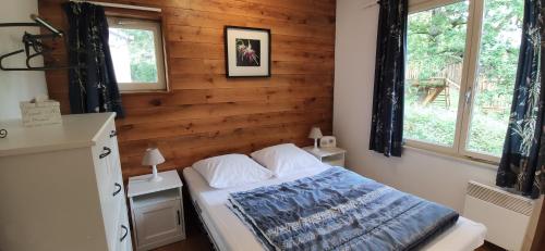 1 dormitorio con 1 cama con pared de madera en Au repaire des écureuils, en Waulsort