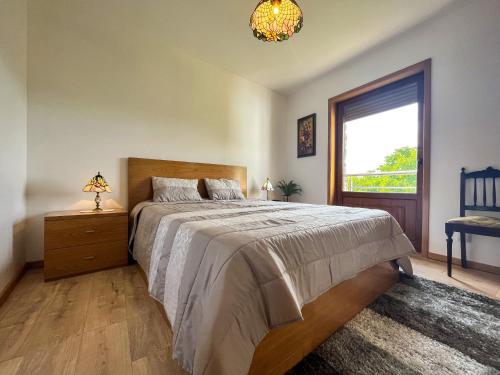 um quarto com uma cama grande e uma janela em Casa da Barriada II em Brangança